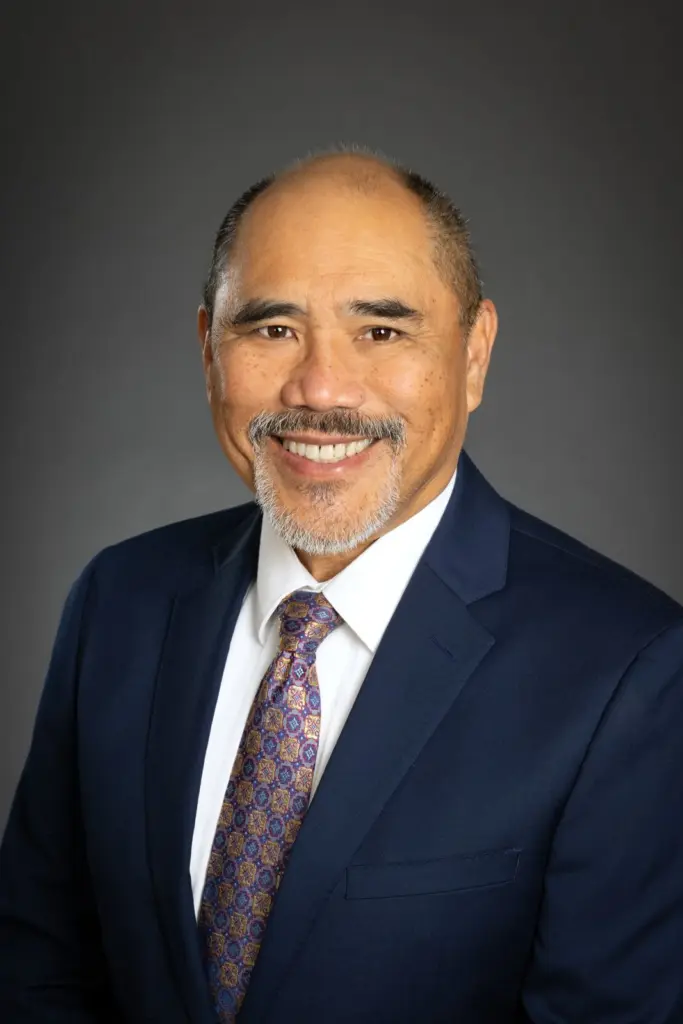 Dr. David Basco, D.C., smiling, in a navy suit